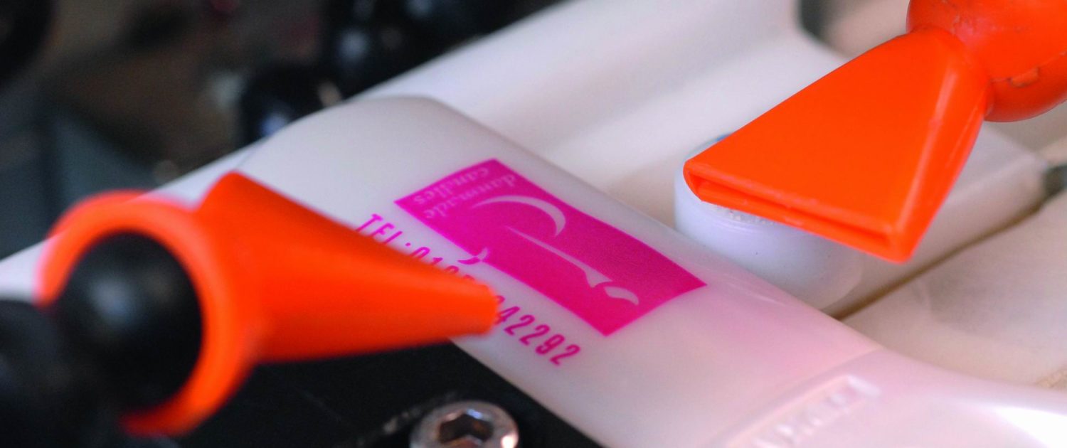 Rote Plastikteile auf einer weißen Fläche.