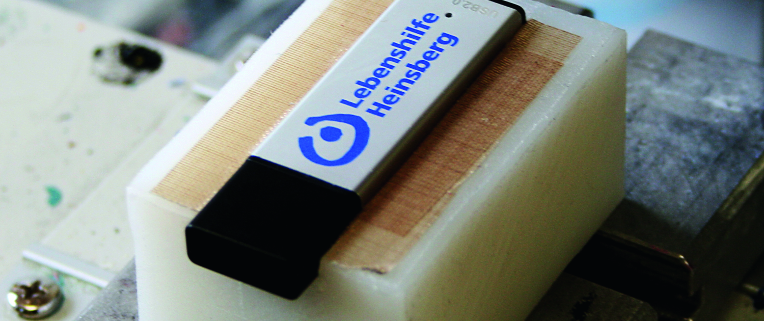 Ein Gerät aus Metall und weißem Kunststoff. Es hat eine braune Platte darin.