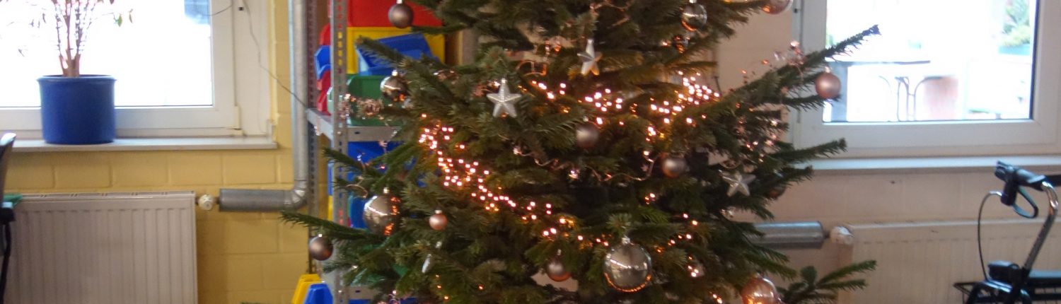 Weihnachtsbaum mit Lichtern und Geschenken. Der Baum steht in einem Raum mit Fenstern und anderen Gegenständen.