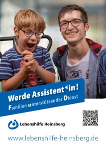 Ein Junge mit Brille hält eine Kamera. Er hat ein blaues T-Shirt an.