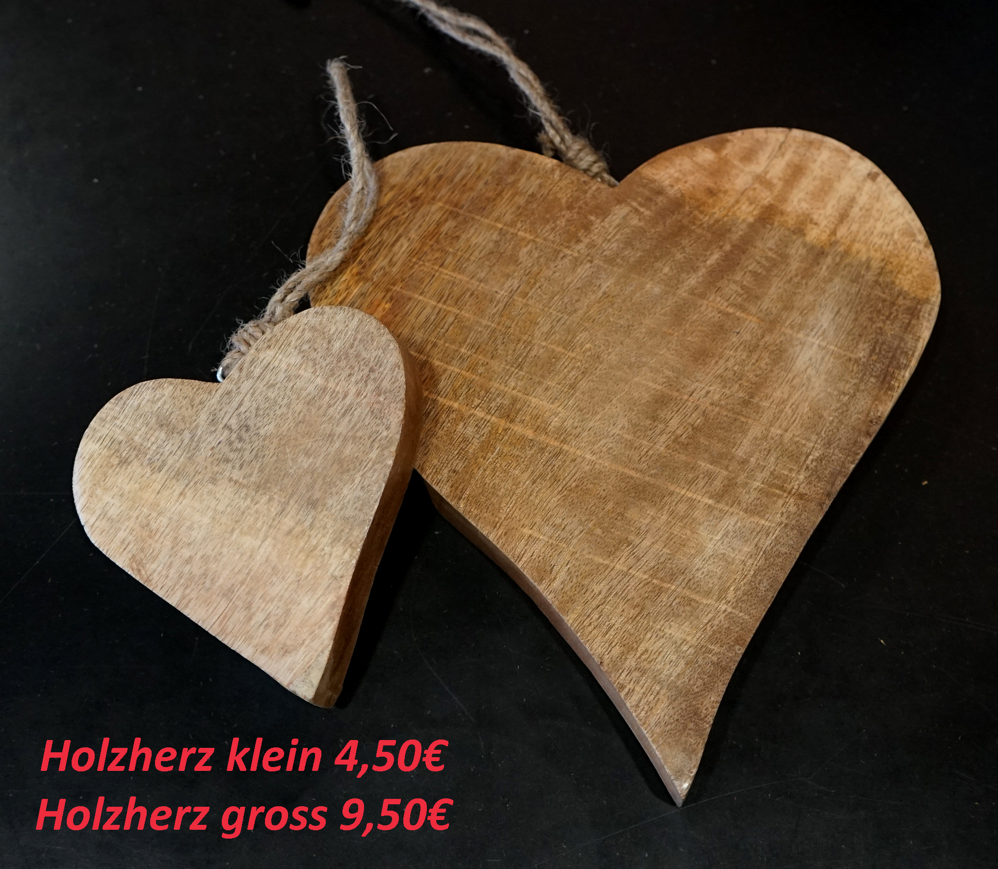Holzherz mit Kordel vor dunklem Hintergrund.