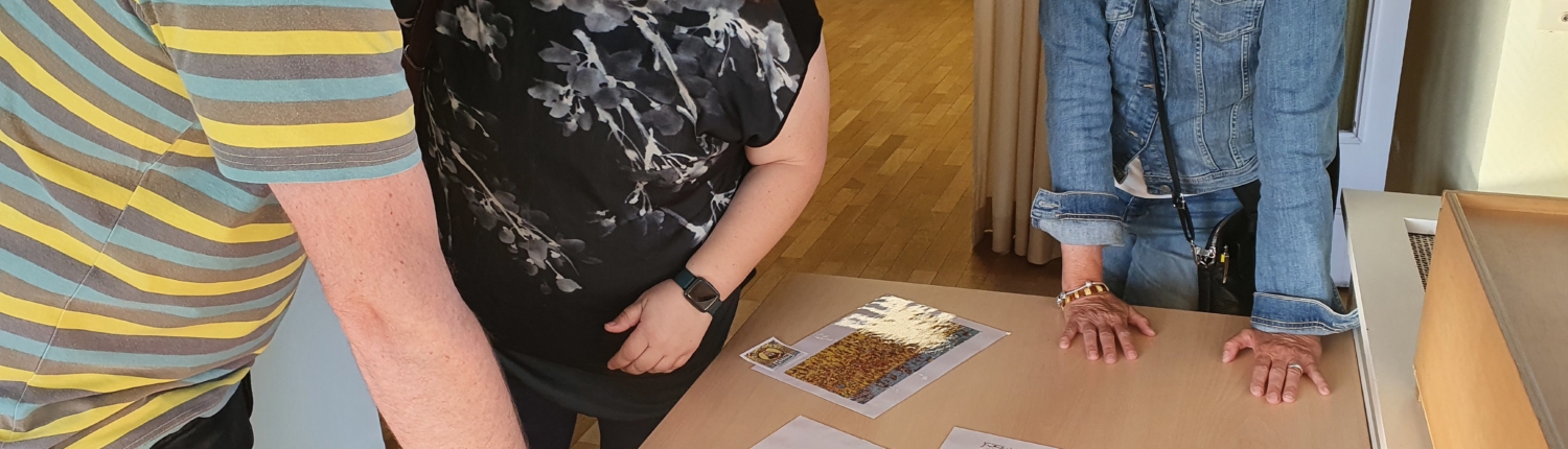 Ein Kind schaut ein Bild an. Es hält ein Blatt Papier in der Hand. Im Hintergrund ist ein Zimmer zu sehen.