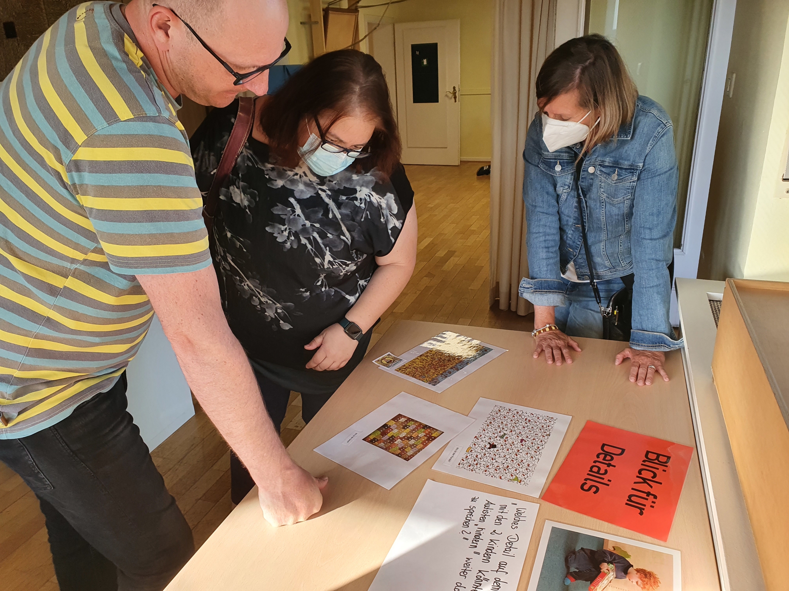 Ein Kind schaut ein Bild an. Es hält ein Blatt Papier in der Hand. Im Hintergrund ist ein Zimmer zu sehen.