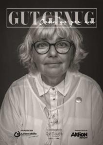 Eine Frau lächelt. Sie trägt eine Brille und ein weißes Hemd.