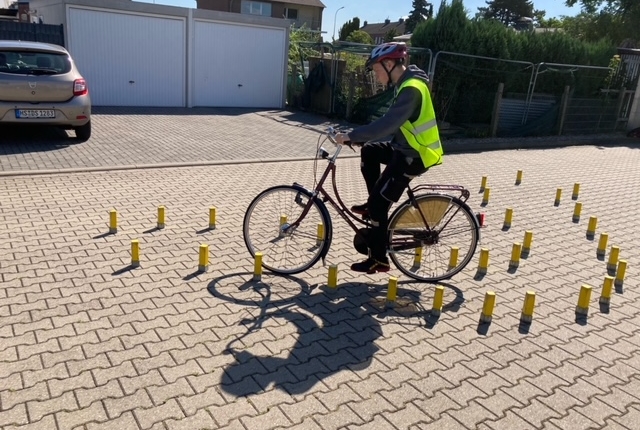 Ein Mann fährt Fahrrad. Er hat eine Warnweste an.