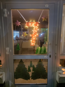 Weihnachtsdeko mit Lichtern. Ein Baum aus Lichtern hängt an der Decke. Es sieht gemütlich aus.