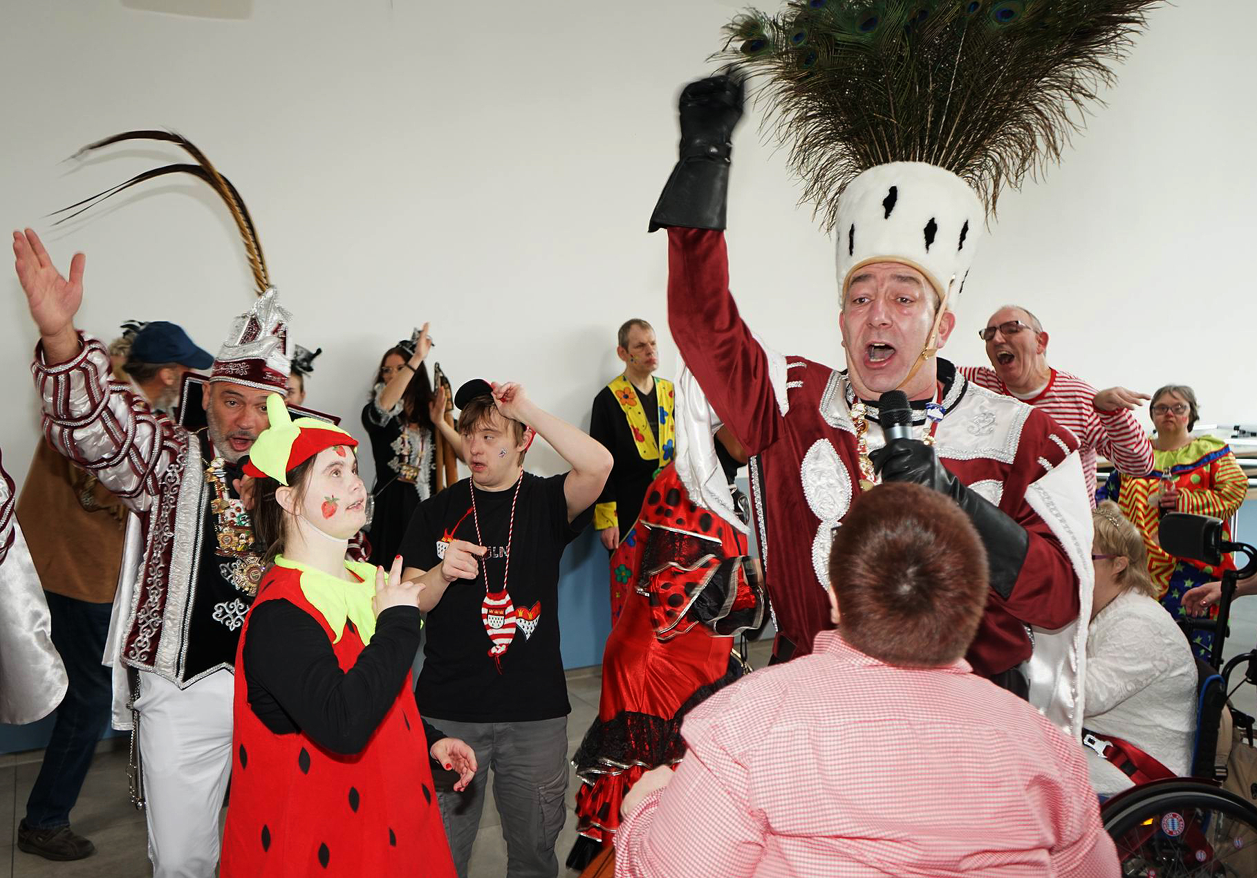 Viele Leute mit Kostümen stehen zusammen. Einige lachen und machen mit den Händen Zeichen.