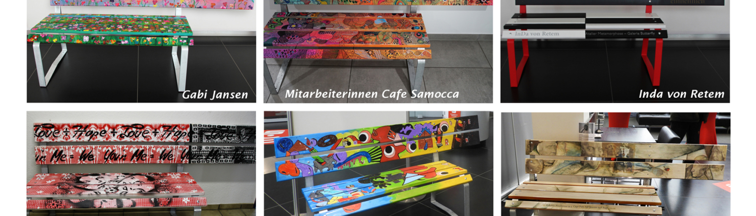 Bunte Kinderbilder hängen an einer Wand. Ein Tisch mit vielen Zeichnungen steht davor.