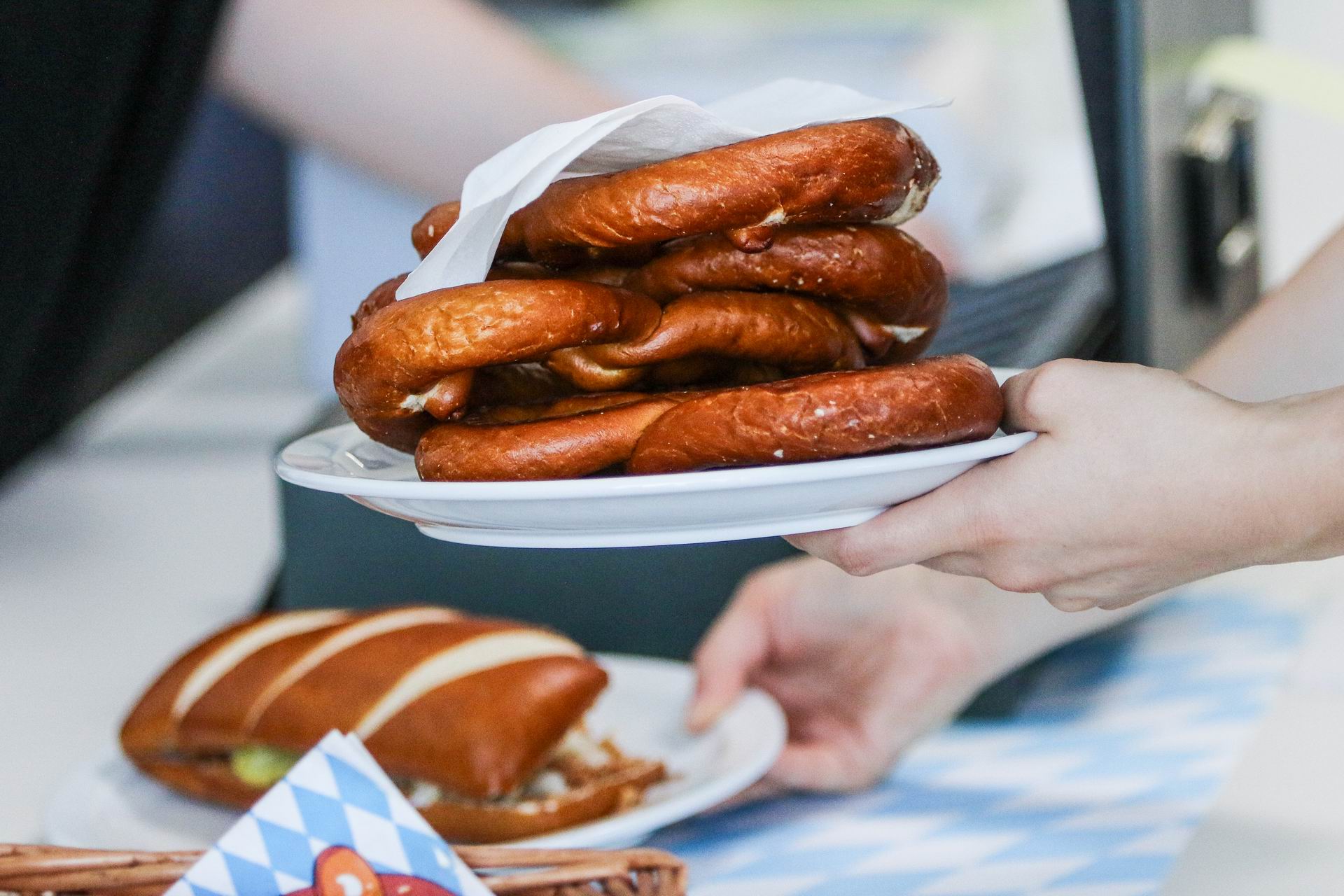 Brezen auf einem Teller. Jemand hält den Teller.