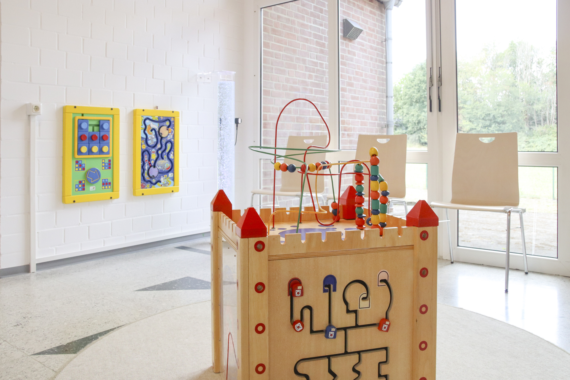IFF-15052025-18 Ein Holz-Spielzeug mit bunten Kugeln steht vor einer Wand. Es ist ein Spiel für Kinder.