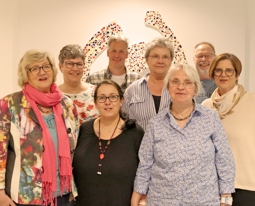 2023_Elternbeirat Gruppenfoto Eine Gruppe von Menschen steht vor einer Wand. Sie lächeln und schauen in die Kamera.