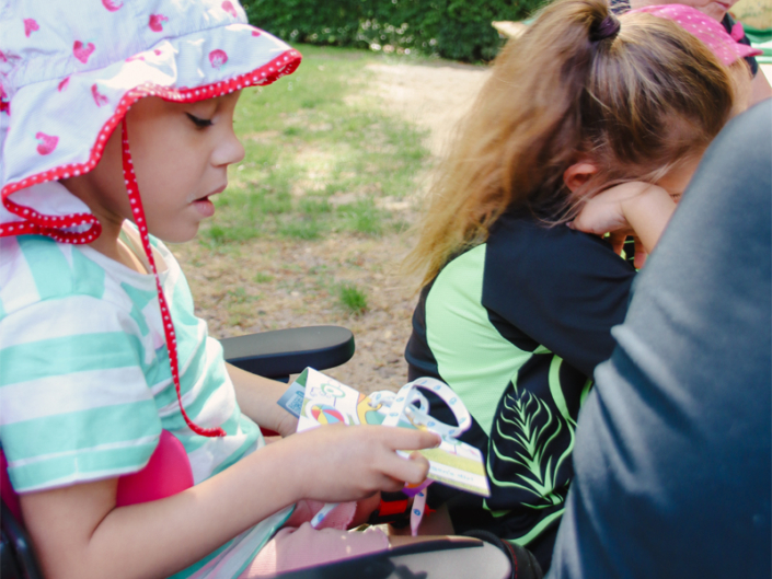 Ein Kind sitzt in einem Kinderwagen und hält ein Spielzeug.