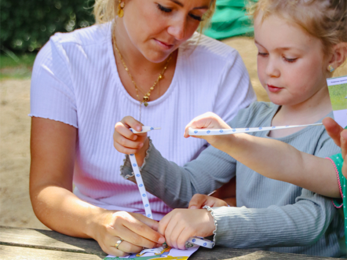 Zwei Mädchen messen etwas mit einem Maßband.