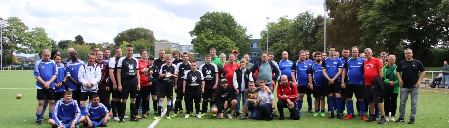 Eine Fußballmannschaft steht auf dem Spielfeld. Die Spieler stehen dicht aneinander.