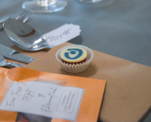 Ein Cupcake in einem Papierförmchen liegt auf einem Tisch.