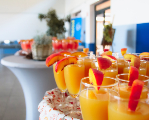 Gläser mit Orangensaft auf einem Tisch. Jeder Glas hat ein Stück Orange.