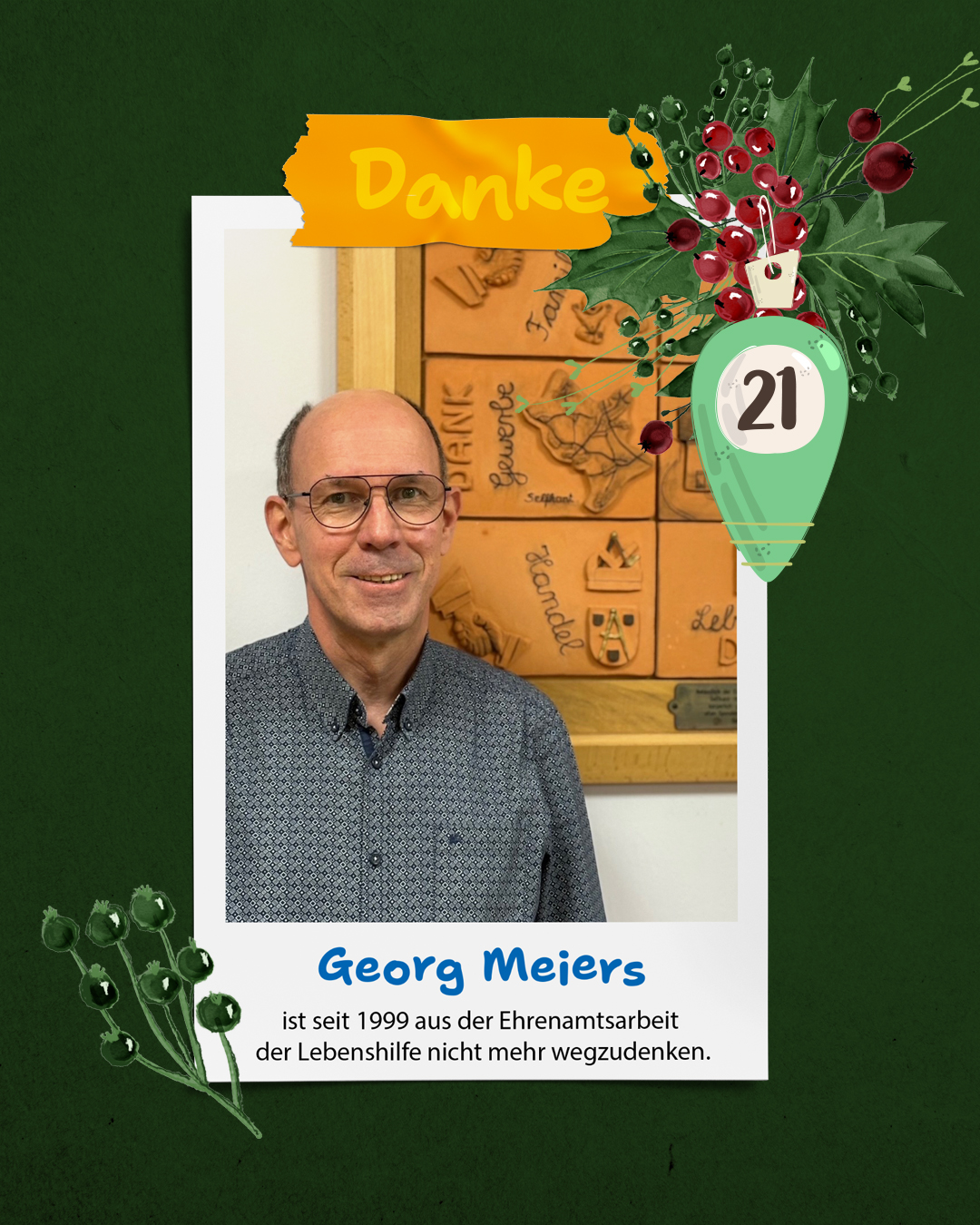 Ein Mann lächelt. Er hat kurze graue Haare und trägt eine Brille. Er hat ein blaues Hemd an.