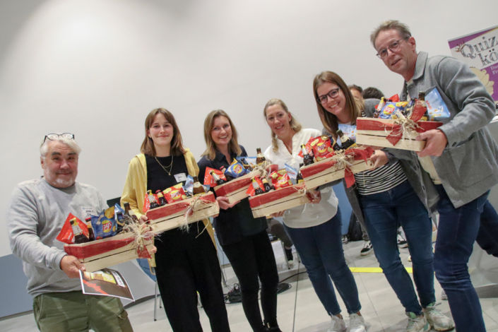 Menschen stehen zusammen. Sie halten Geschenkkörbe mit Essen und Getränken.