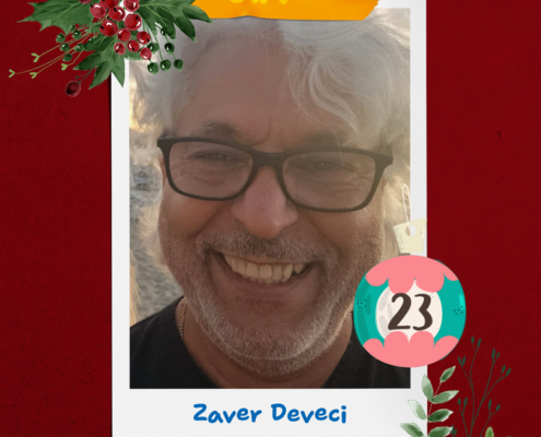 Mann mit grauem Haar und Brille lächelt freundlich in die Kamera. Er trägt ein schwarzes Hemd.