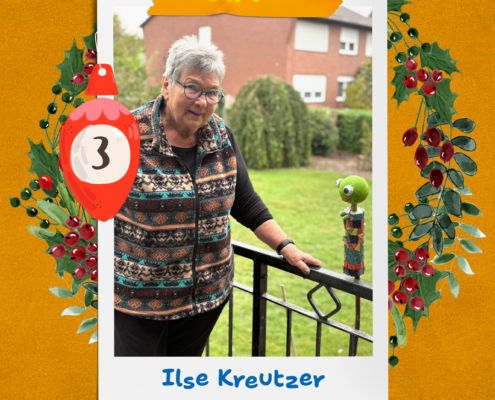 Eine Frau steht vor einem Haus. Sie trägt eine Jacke und eine Brille.
