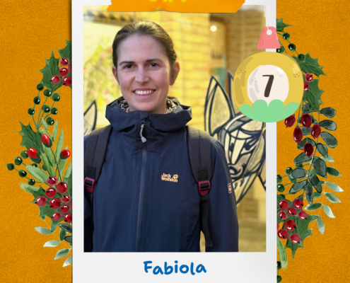 Eine Frau steht im Schnee. Sie hat eine Jacke an. Es ist kalt draußen.