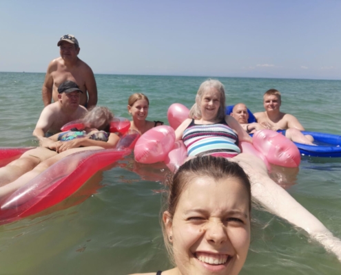 Menschen schwimmen im Meer. Sie liegen auf Luftmatratzen. Es ist sonnig.