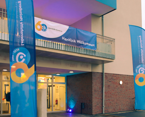 Ein helles Gebäude mit einer Tür. Es sieht aus wie ein Haus für Leute.