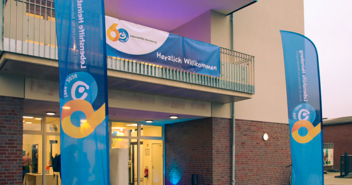 Ein helles Gebäude mit einer Tür. Es sieht aus wie ein Haus für Leute.